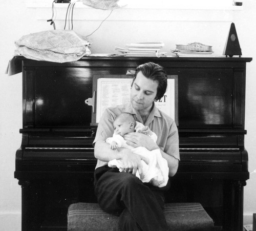 Robert sitting at his Heinzman piano in Vancouver with son Virgil